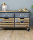 Wooden dresser with metal accents on a wooden floor, decorated with a gold cat figurine and a lantern.