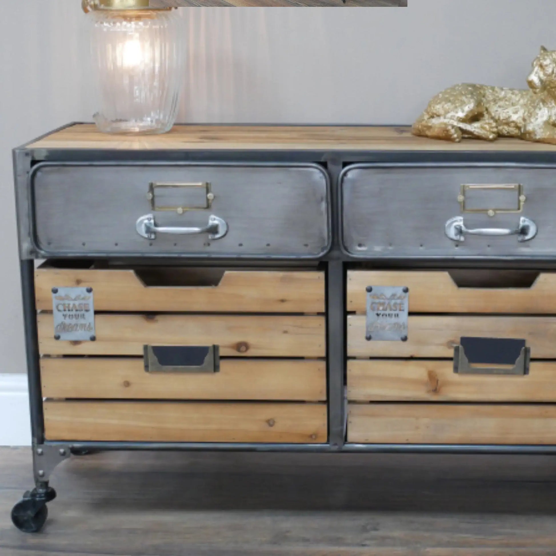 Wooden dresser with metal drawers and wheels on a wooden floor.