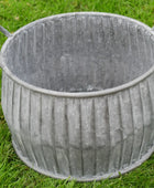Metal planter with ribbed texture on a grass background