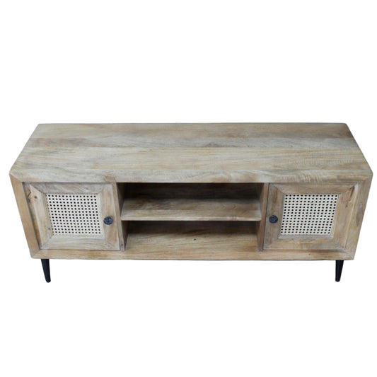 Wooden TV stand with rattan doors on a wooden floor against a gray wall.
