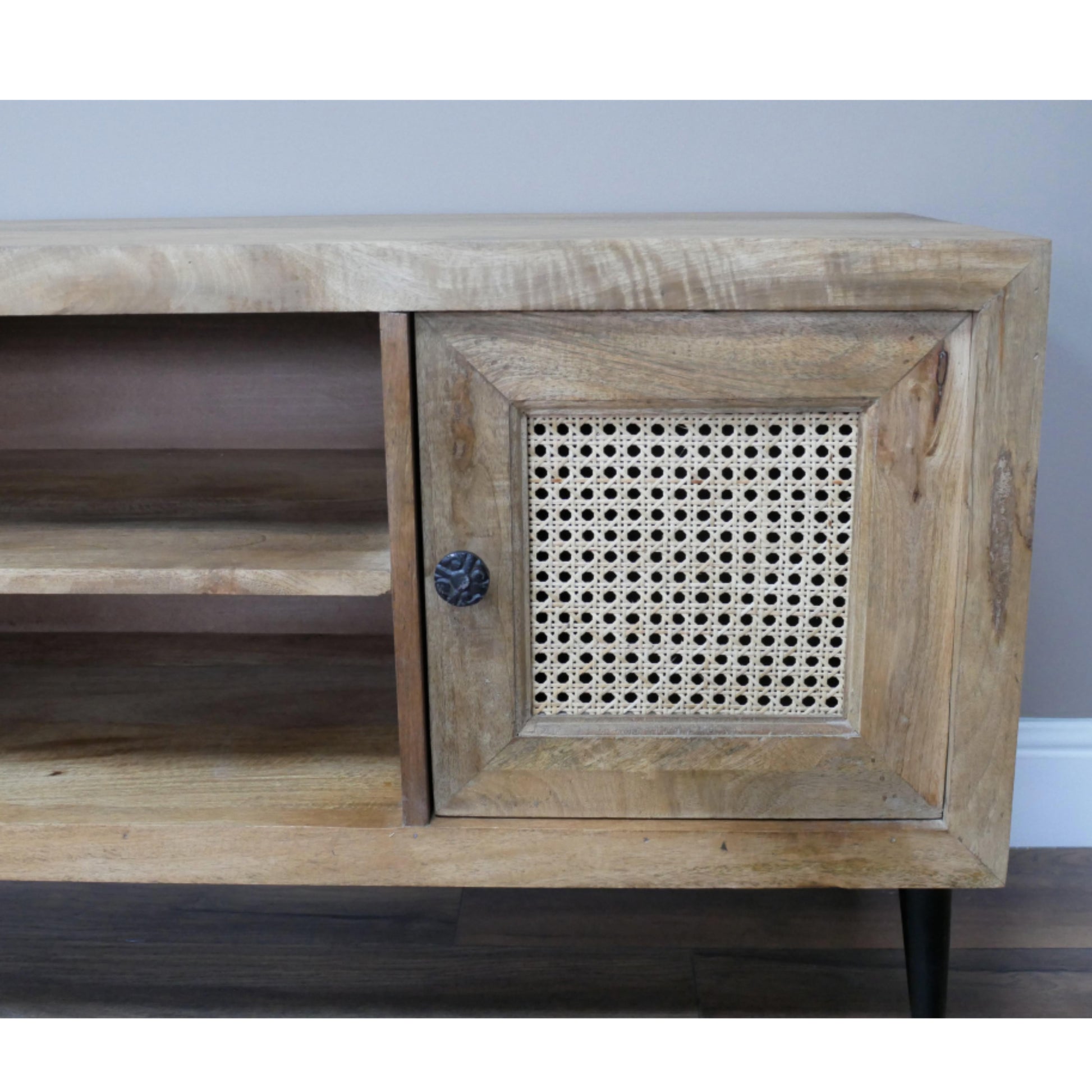 Wooden console table with a decorative metal grille on a plain background