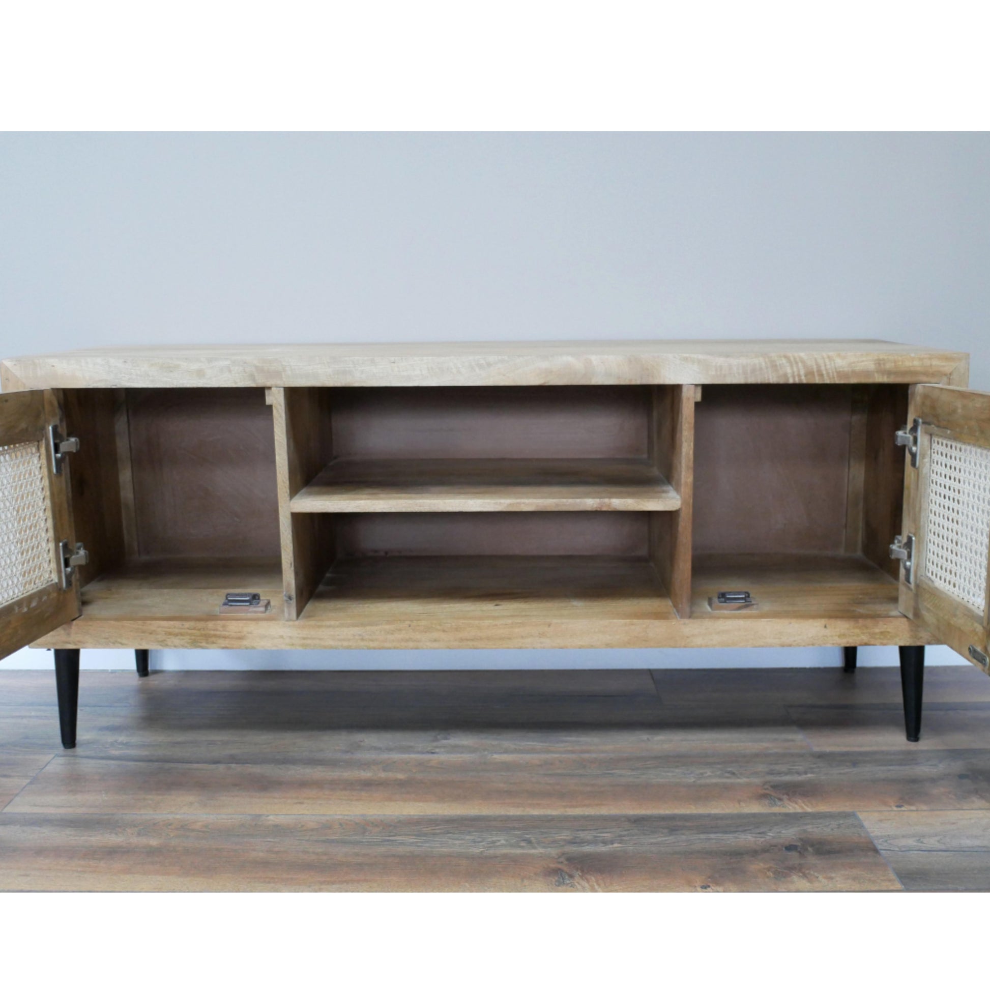 Wooden cabinet with open doors on a wooden floor against a light gray wall