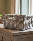 Wicker basket on a wooden surface with a plant and window in the background