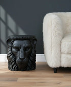 Black lion head sculpture on a wooden surface with a neutral background