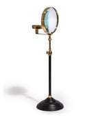 A vintage-style adjustable optical stand with a black pole, brass metal components, and a circular glass lens, shown on a white background with a soft shadow.