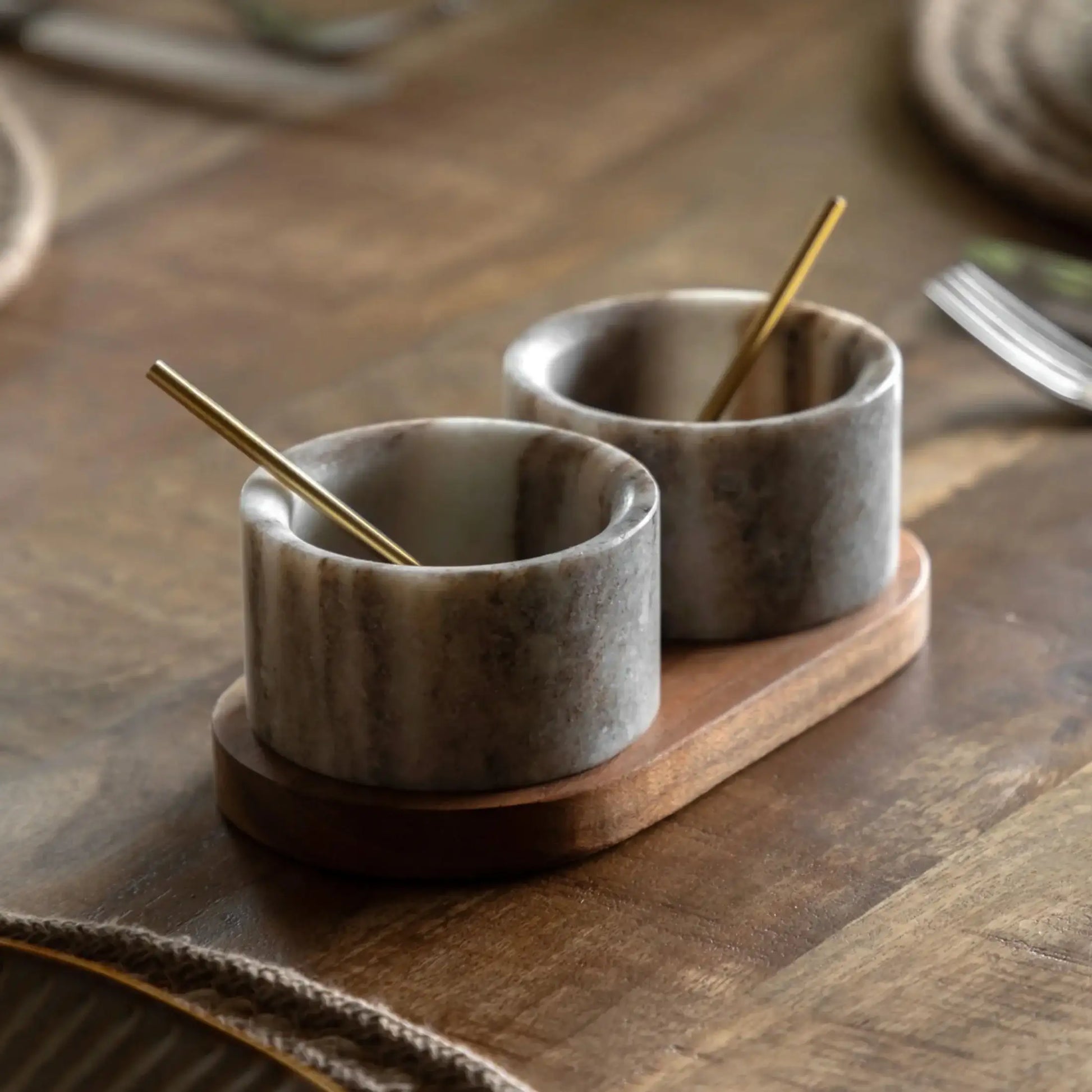 Two marble salt cells with wooden stands on a wooden surface