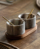 Two marble salt cells with wooden stands on a wooden surface