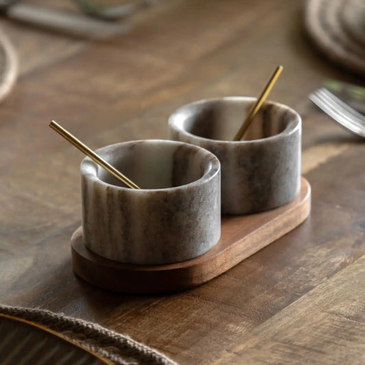 Two marble salt cells with wooden stands on a wooden surface