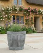 Decorative planter with flowers in front of a stone building