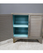 Metal cabinet with open doors revealing a turquoise interior against a gray wall.