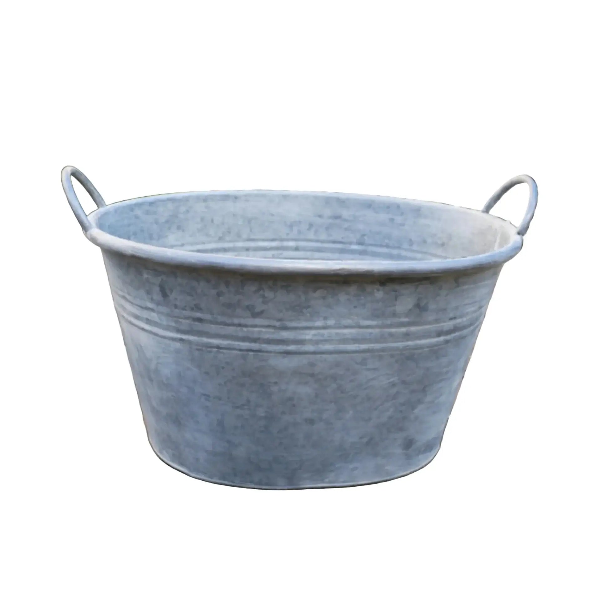 Galvanized metal tub on a stone patio with garden background