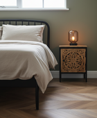 Bedroom with a bed and nightstand featuring a lamp.