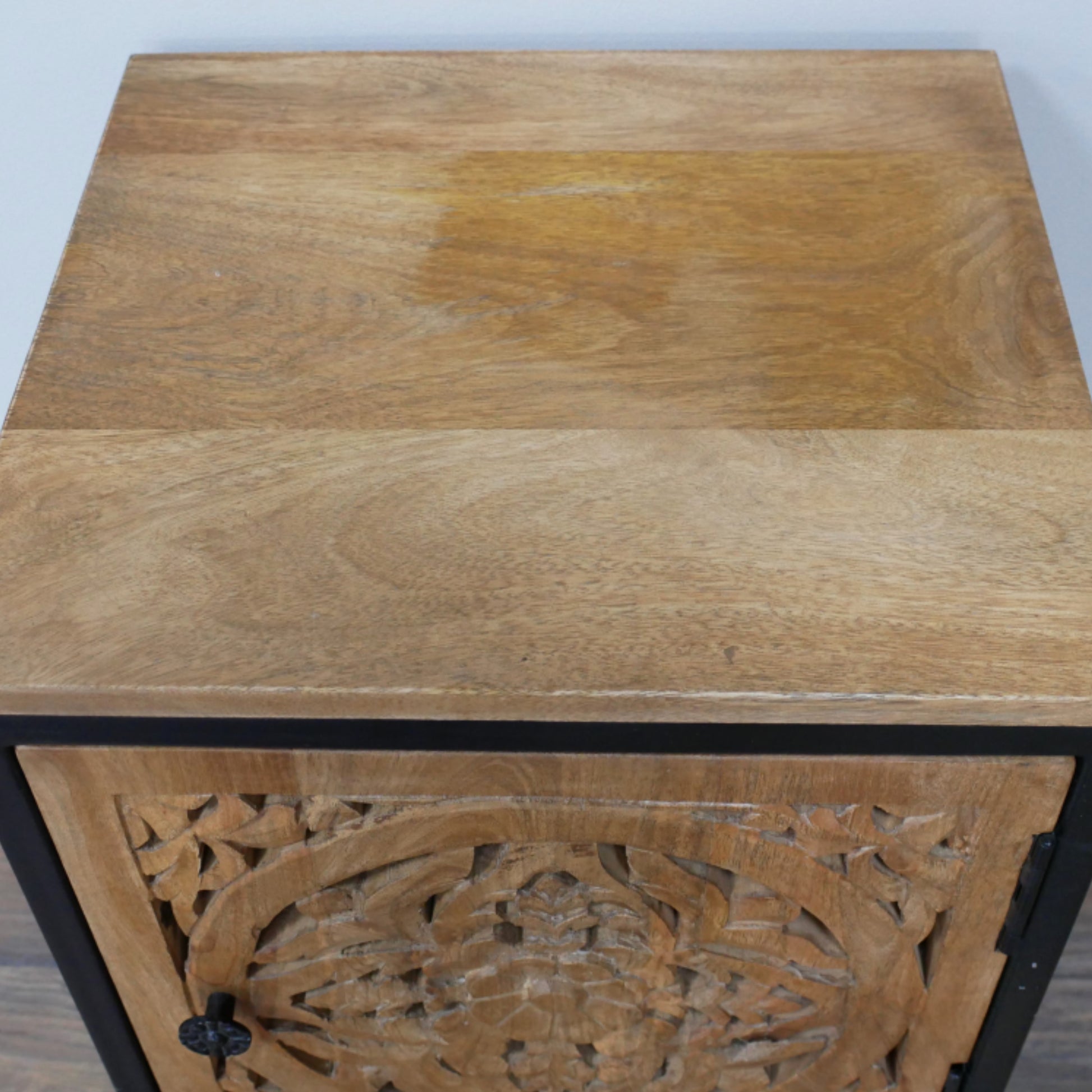 Wooden side table with intricate carvings on a plain background