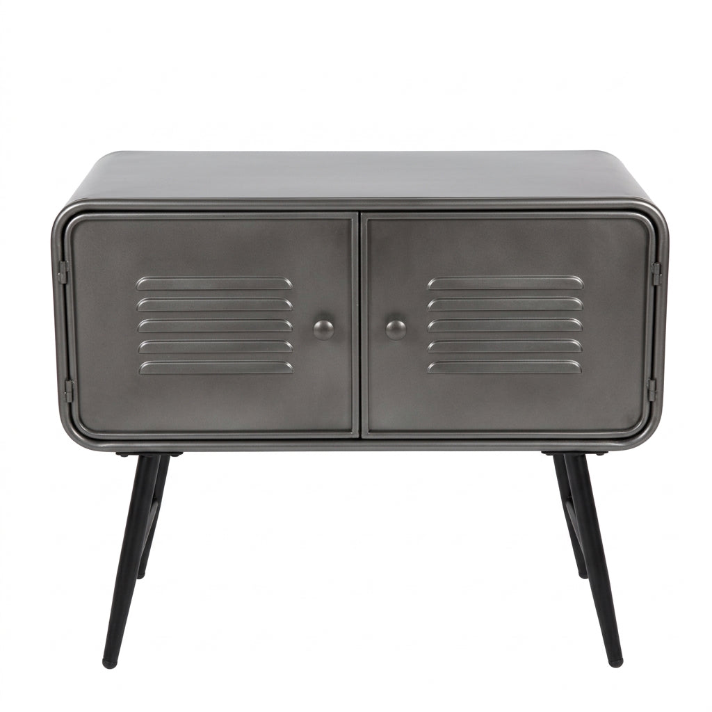 A rustic industrial sideboard cabinet with a galvanized steel finish, featuring two doors with horizontal vent slats, angled metal legs, and decorative items on top, set against a brick wall and wooden floor.