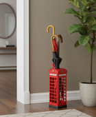 Red umbrella stand with a phone box design next to a potted plant in a room.
