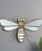Decorative insect wall art with reflective wings on a white background