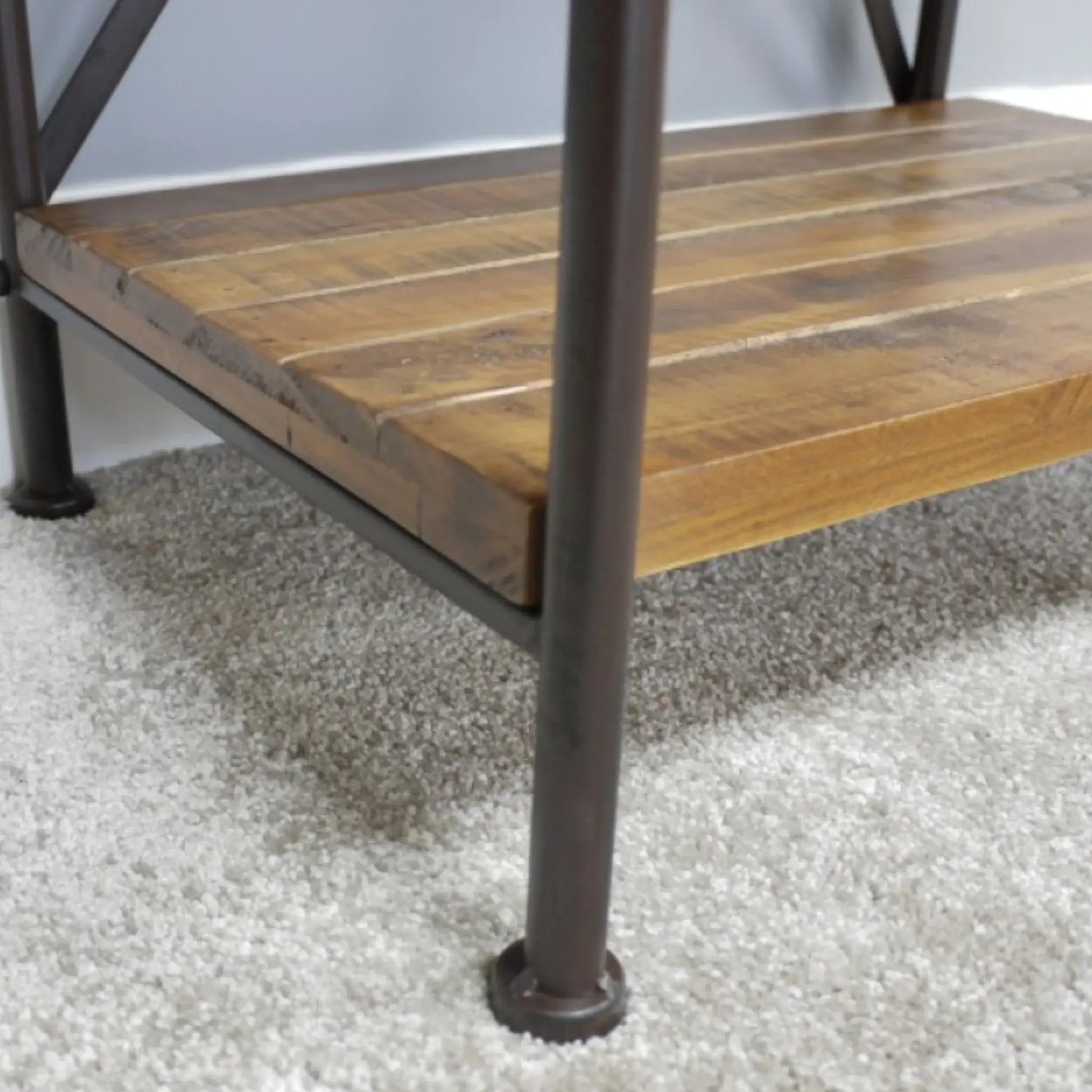 Wooden shelf with metal legs on a carpeted floor