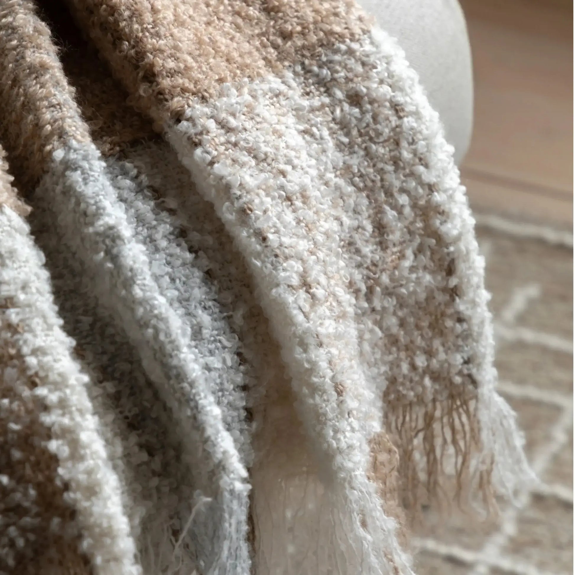 Close-up of a textured beige and brown blanket with a blurred background