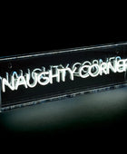 Neon sign with 'NAUGHTY CORNER' text inside a clear acrylic box on a black background