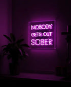 Neon sign with 'Nobody Gets Out Sober' text in a dark room with purple lighting.
