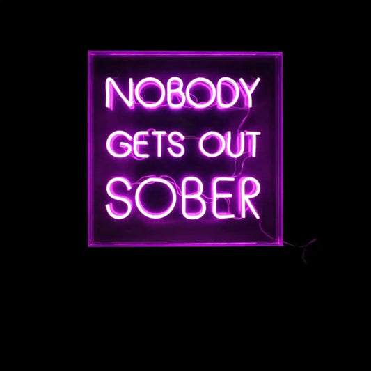 Neon sign with the text 'NOBODY GETS OUT SOBER' on a black background