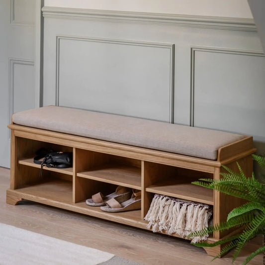 Wooden bench with cushion and storage compartments against a paneled wall.