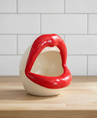 Red and white ceramic lip-shaped object on a white background