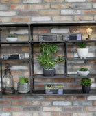 Industrial-style metal shelving unit with decorative items against a brick wall.