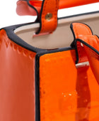 Close-up of an orange handbag with a black handle on a white background
