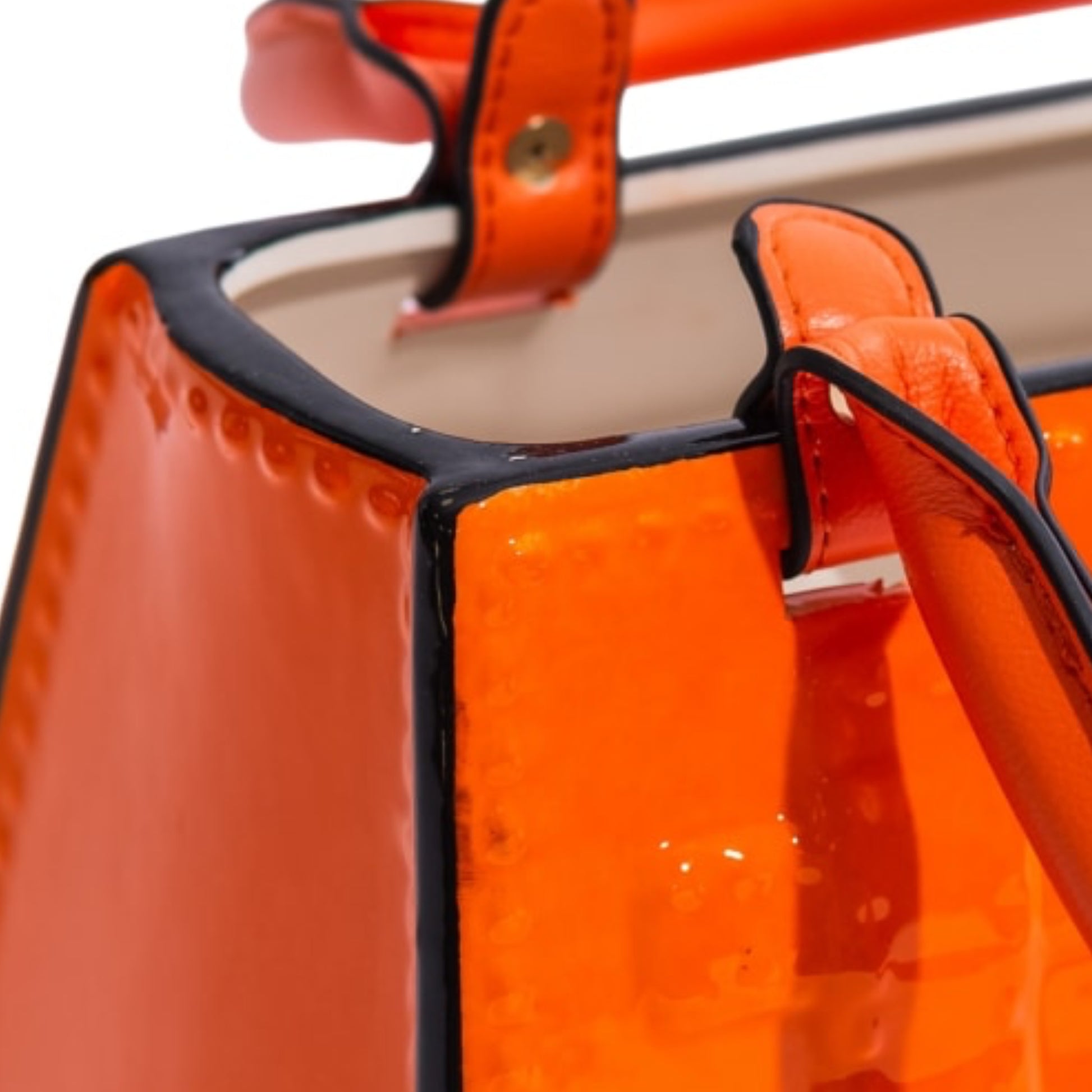 Close-up of an orange handbag with a black handle on a white background