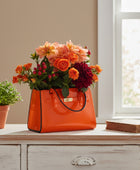 Orange handbag filled with flowers on a white background