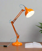 Orange desk lamp with a white light bulb on a white background