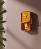 Yellow wall clock with fish design on a beige wall
