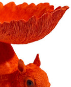 Orange squirrel with a large orange bowl on its head against a white background