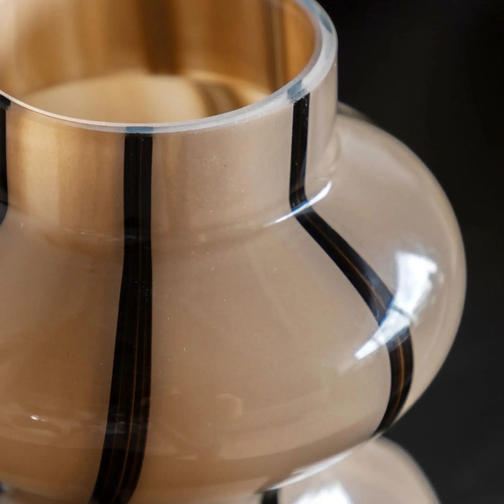 Close-up of a glass with a black band around it on a dark background