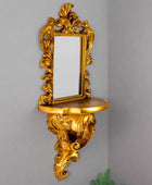 Decorative gold wall mirror with shelf on a white background