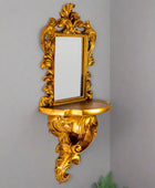 Decorative gold wall mirror with shelf on a white background