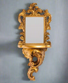 Decorative gold mirror with intricate designs on a white background