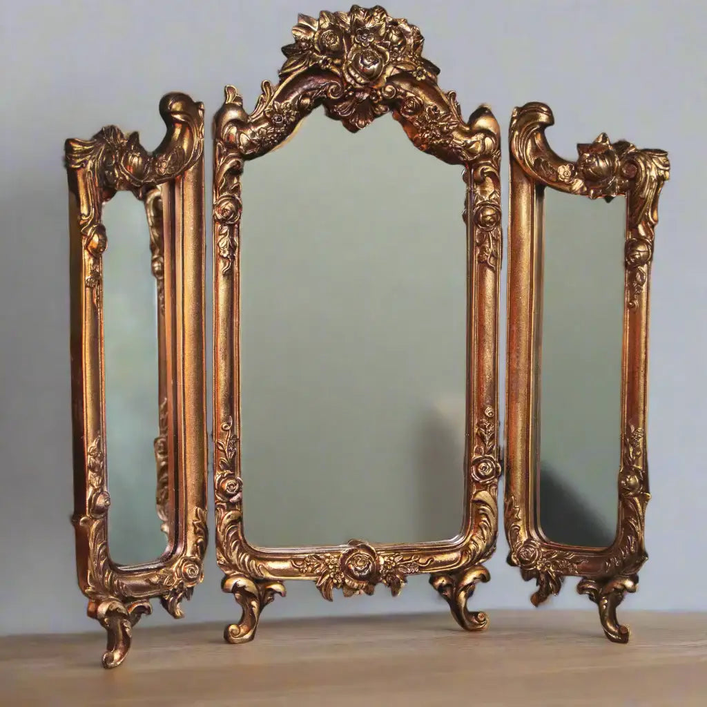 Ornate gold mirror set on a plain background