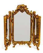 Gold ornate tri-fold mirror on a white background