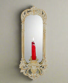 Decorative wall mirror with a candle holder on a white background