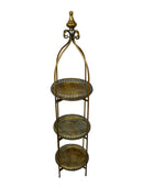 Decorative metal shelf with three tiers against a plain wall.