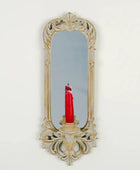 Decorative wall mirror with a candle holder on a white background