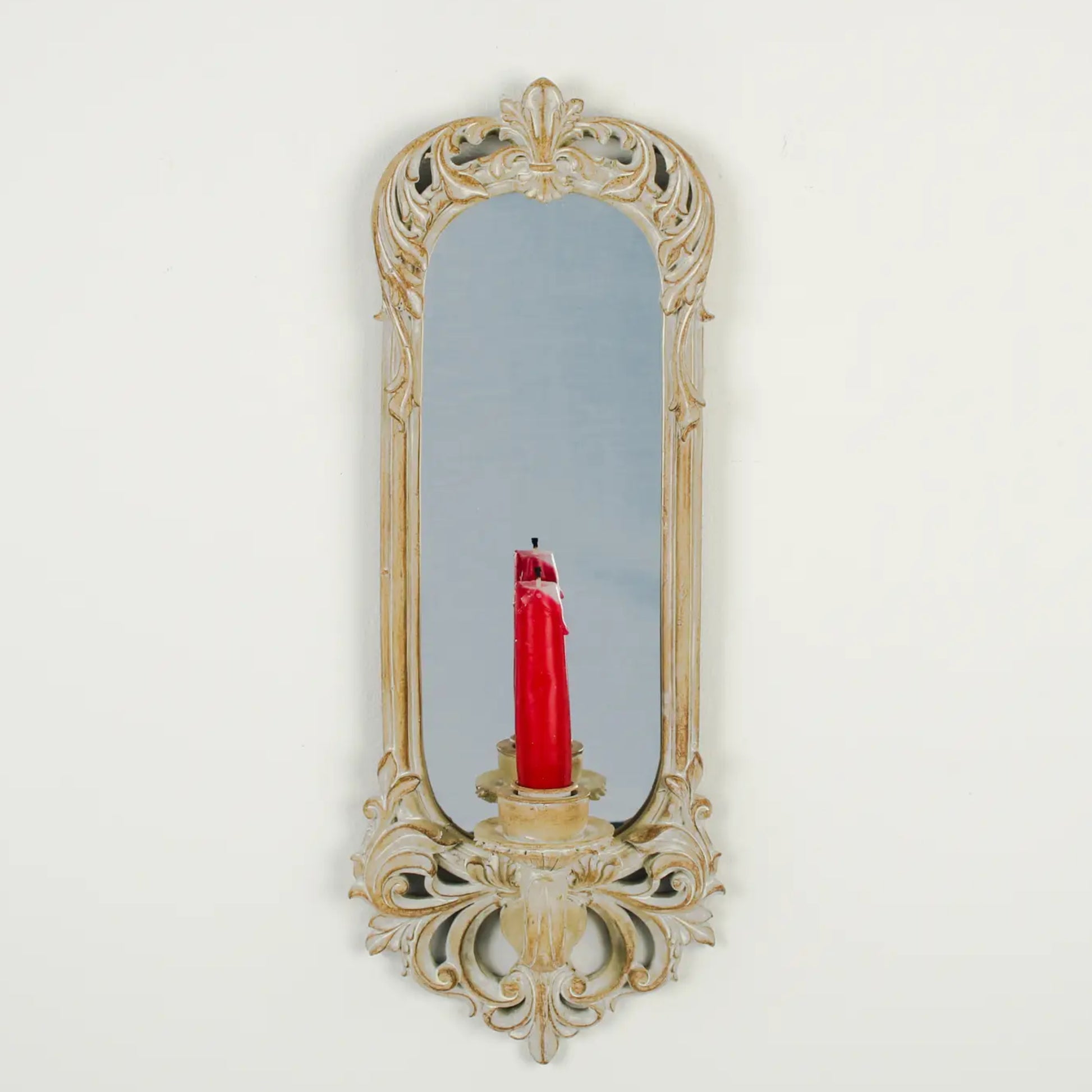 Decorative wall mirror with a candle holder on a white background