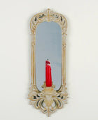 Decorative wall mirror with a candle holder on a white background