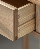 Close-up of a wooden drawer with dovetail joint on a gray background