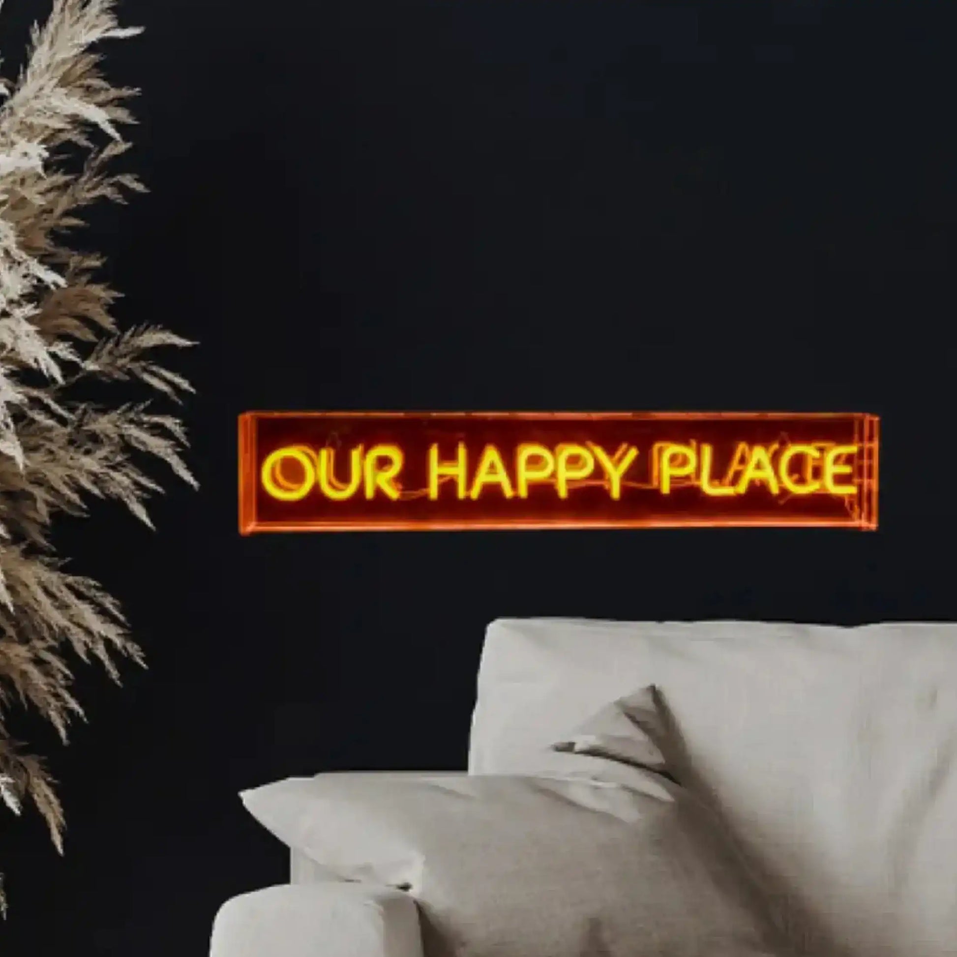 Neon sign reading 'OUR HAPPY PLACE' in a living room setting with a couch and decorative plant.