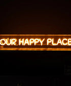 Neon sign with 'OUR HAPPY PLACE' text on a dark background