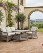 Outdoor patio setting with wicker furniture, potted plants, and a scenic view.