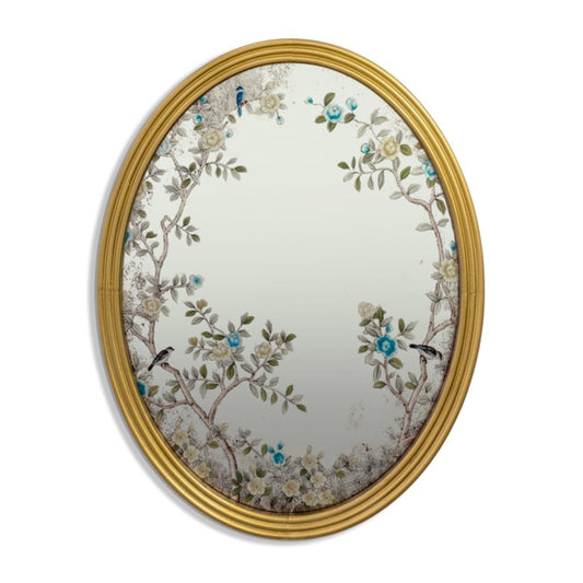 Decorative oval mirror with floral and bird design in a gold frame on a white background
